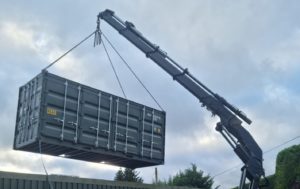 20ft side access shipping container being offloaded with a HIAB crane.