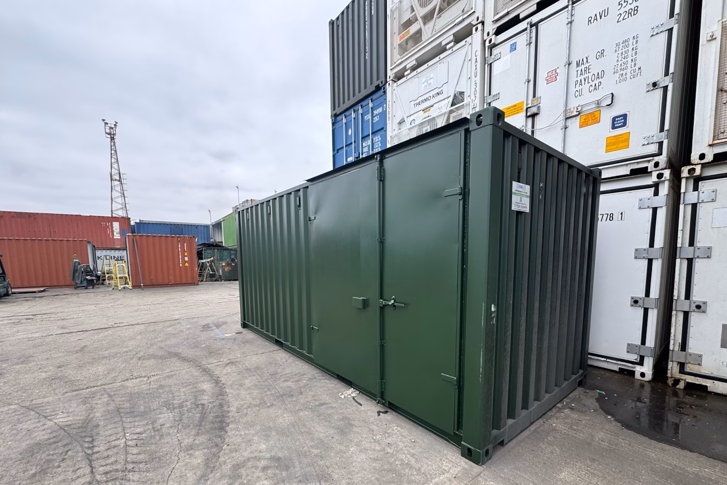 Green container converted into a storage unit with a door